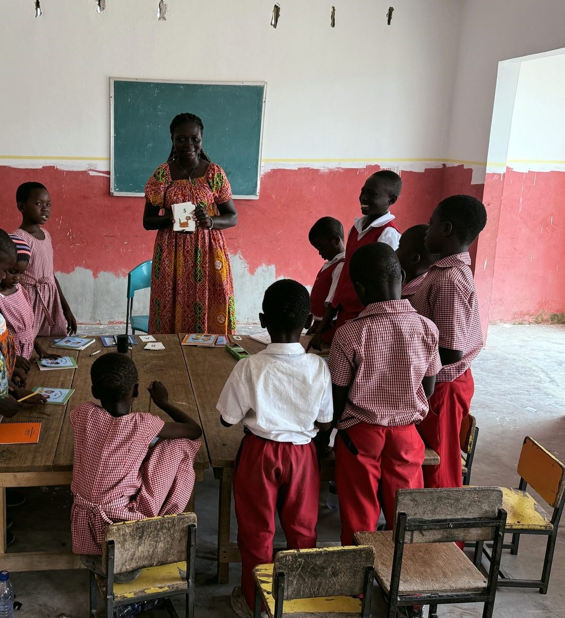 A teacher holding up a letter-S sound card to a class of children