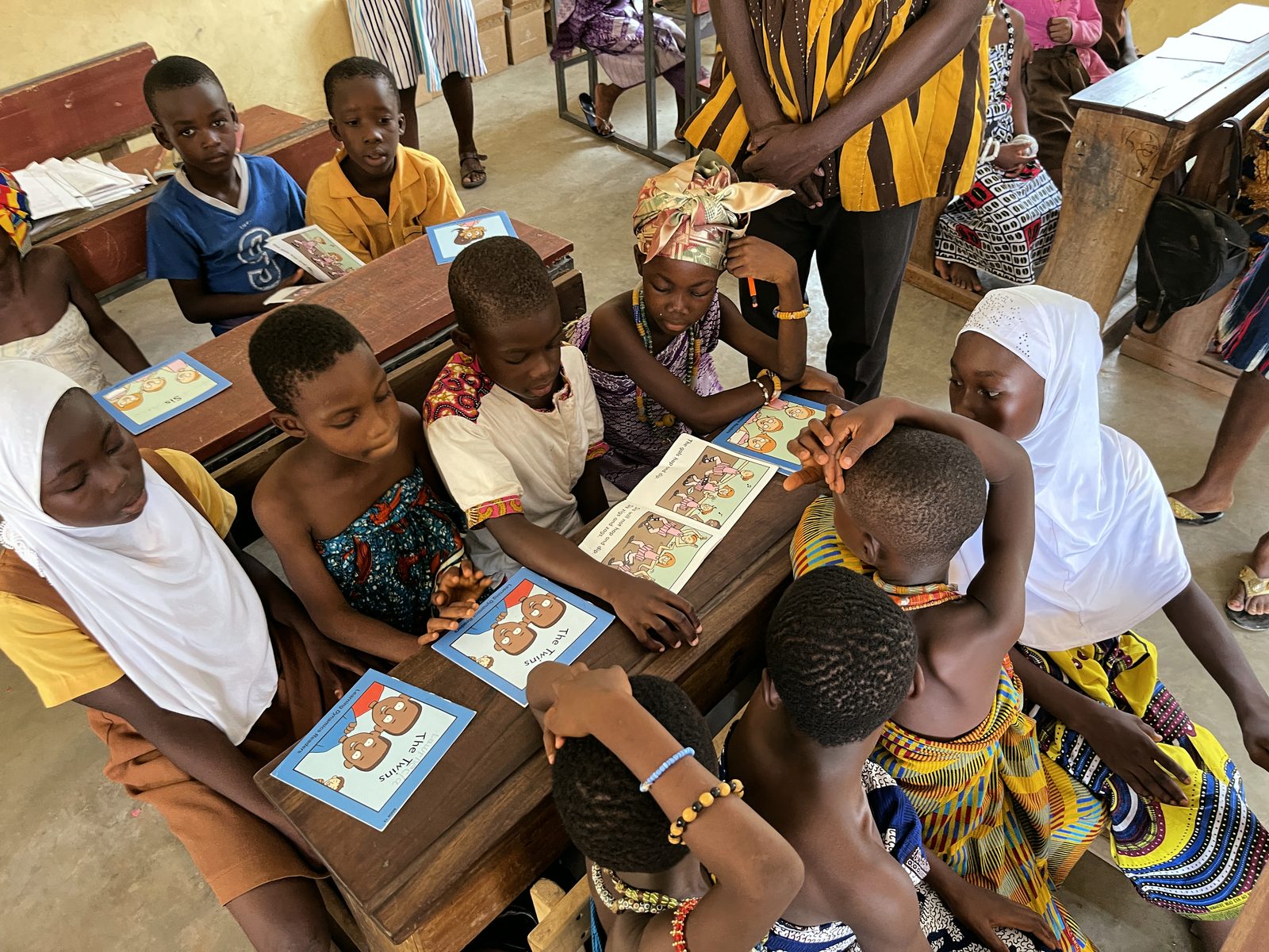 Children reading a storybook aloud together at their desk