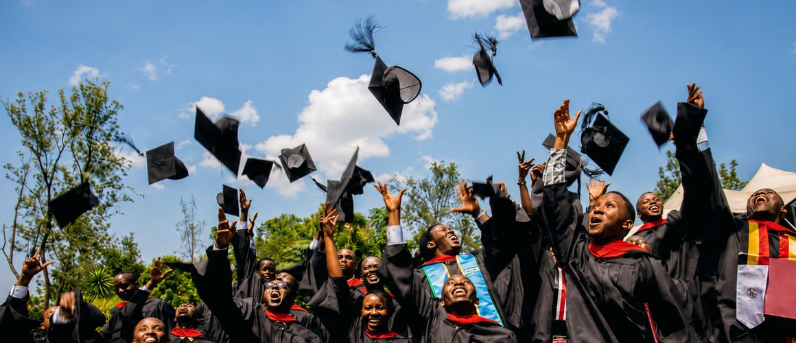 Graduates in caps and gowns throwing their caps into the air